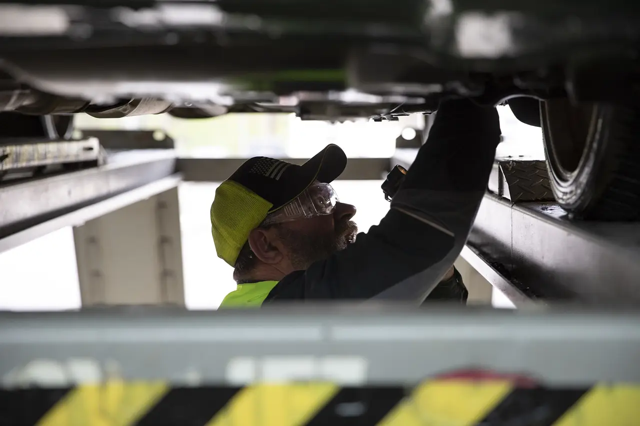 Mechanic inspecting the underside of a vehicle