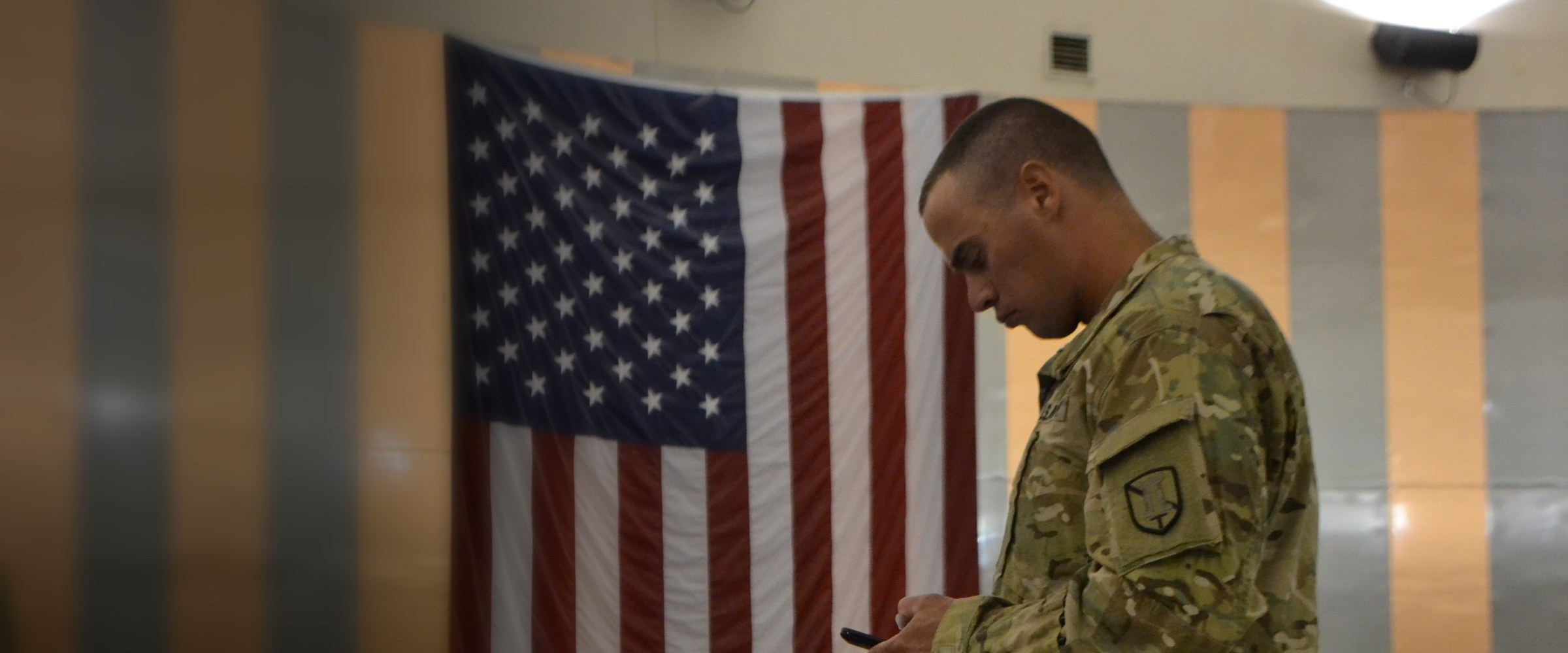 A soldier checking his phone while waiting for a deployment flight